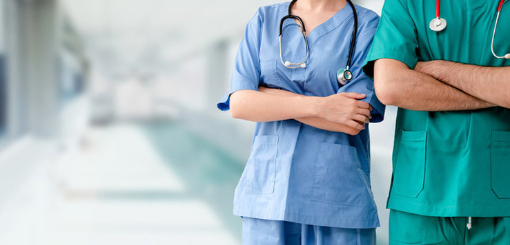Clinical staff in scrubs in a hospital corridor — medical supply workflow context